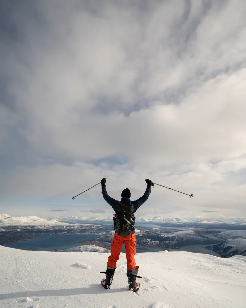 Before: a skier celebrating on a snowy summit