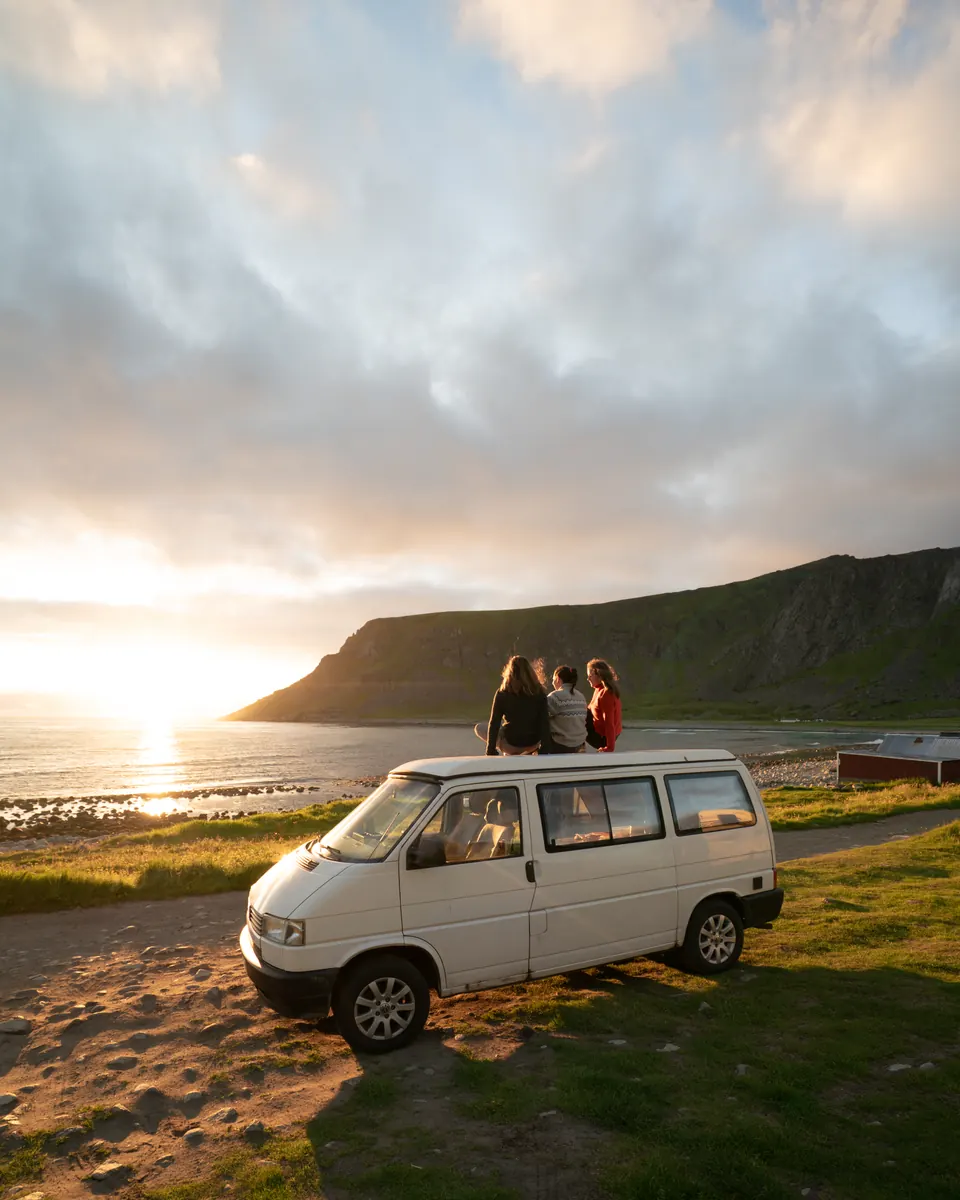 Before: friends on a camper van at a beach at sunset